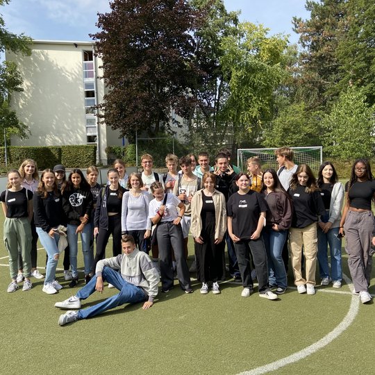 Eine Gruppe Jugendlicher posiert auf einem Fußballplatz am Sportzentrum Ruhr.