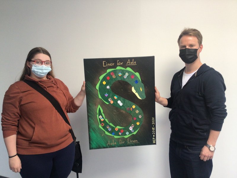 Zwei Personen halten ein Bild in der Hand.