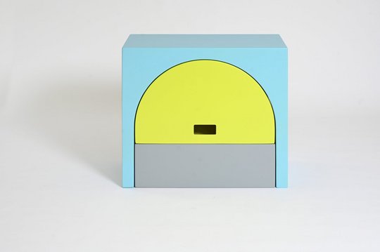 Bunte geometrische Skulptur mit blauen, gelben und grauen Formen.