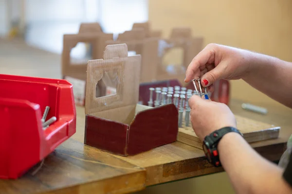 Person konfektioniert Schrauben in Verpackung