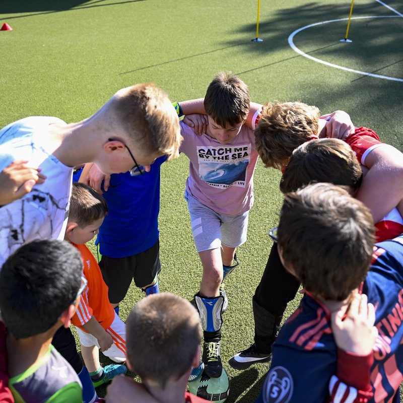 unterschiedliche Kinder bilden einen Kreis auf den Fußballfeld