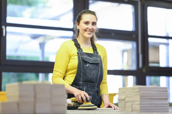 Beschäftigte mit Schleifgerät in der Schreinerei 