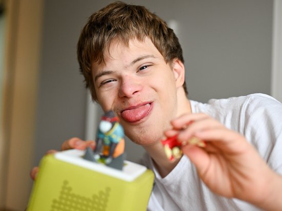 Ein frecher Junge streckt vergnügt beim Spielen die Zunge heraus