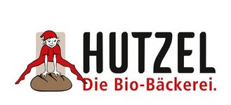 Illustration eines rot gekleideten Wesens auf Brot mit dem Text "HUTZEL Die Bio-Bäckerei."