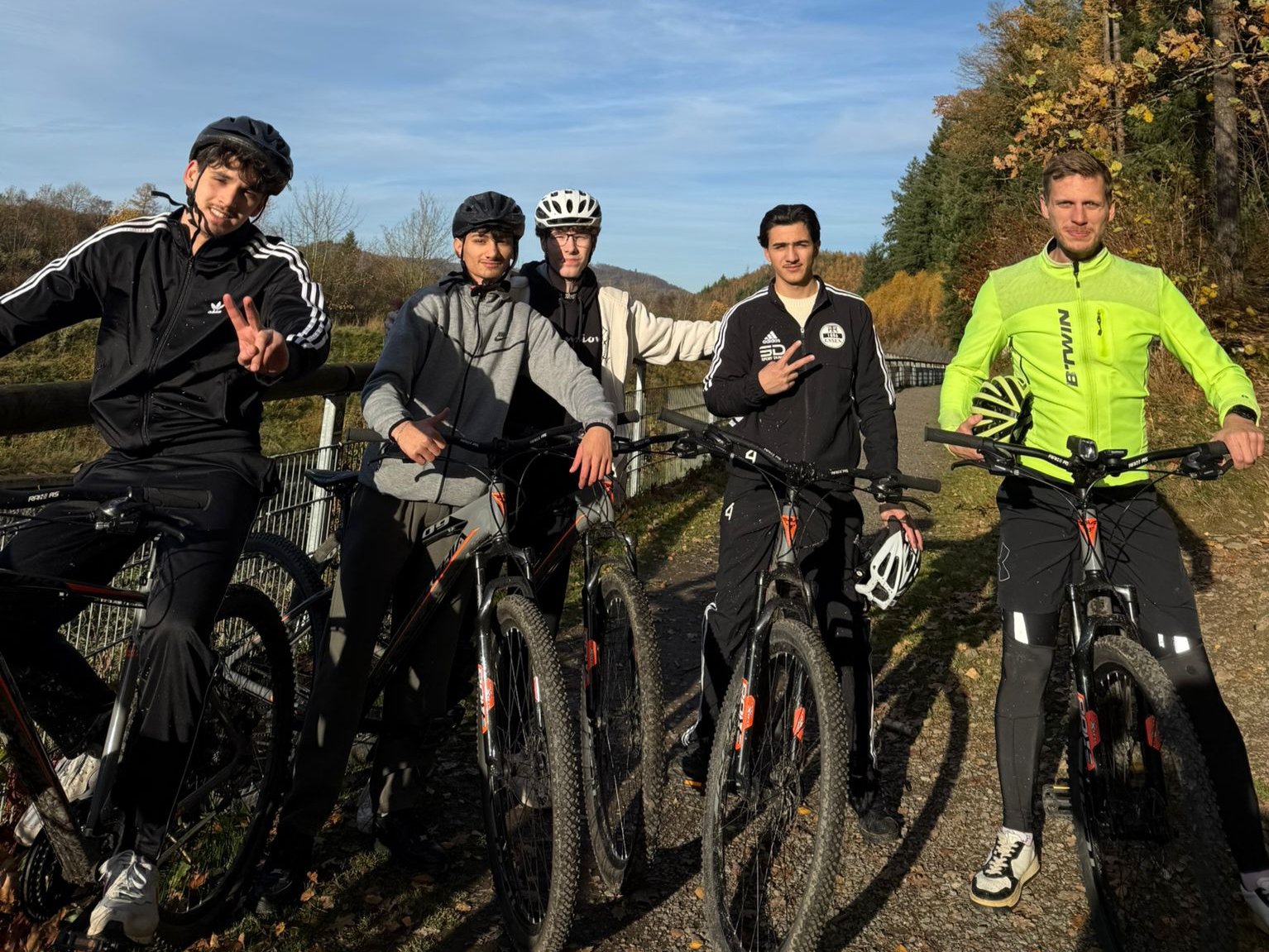Fünf Personen mit ihren Fahrrädern haben sich in der Natur zum Gruppenbild aufgestellt 