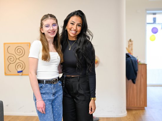 Eine Mitarbeiterin und ein Teenager strahlen sich an