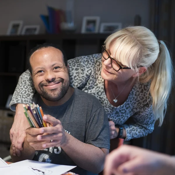 Mitarbeiterin nimmt strahlenden Klienten in den Arm