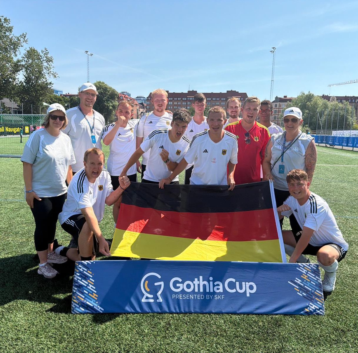 Die Herren-Mannschaft mit einer Deutschlandfahne auf einer Wiese.