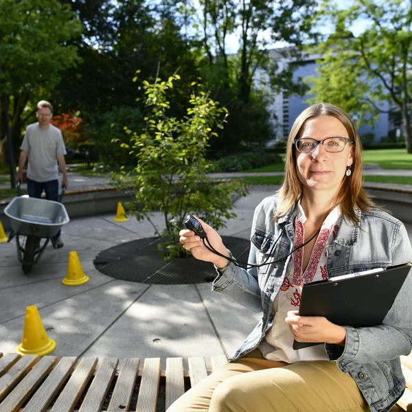 Schubkarrenparcours mit Teilnehmer. Mitarbeiterin stoppt die Zeit