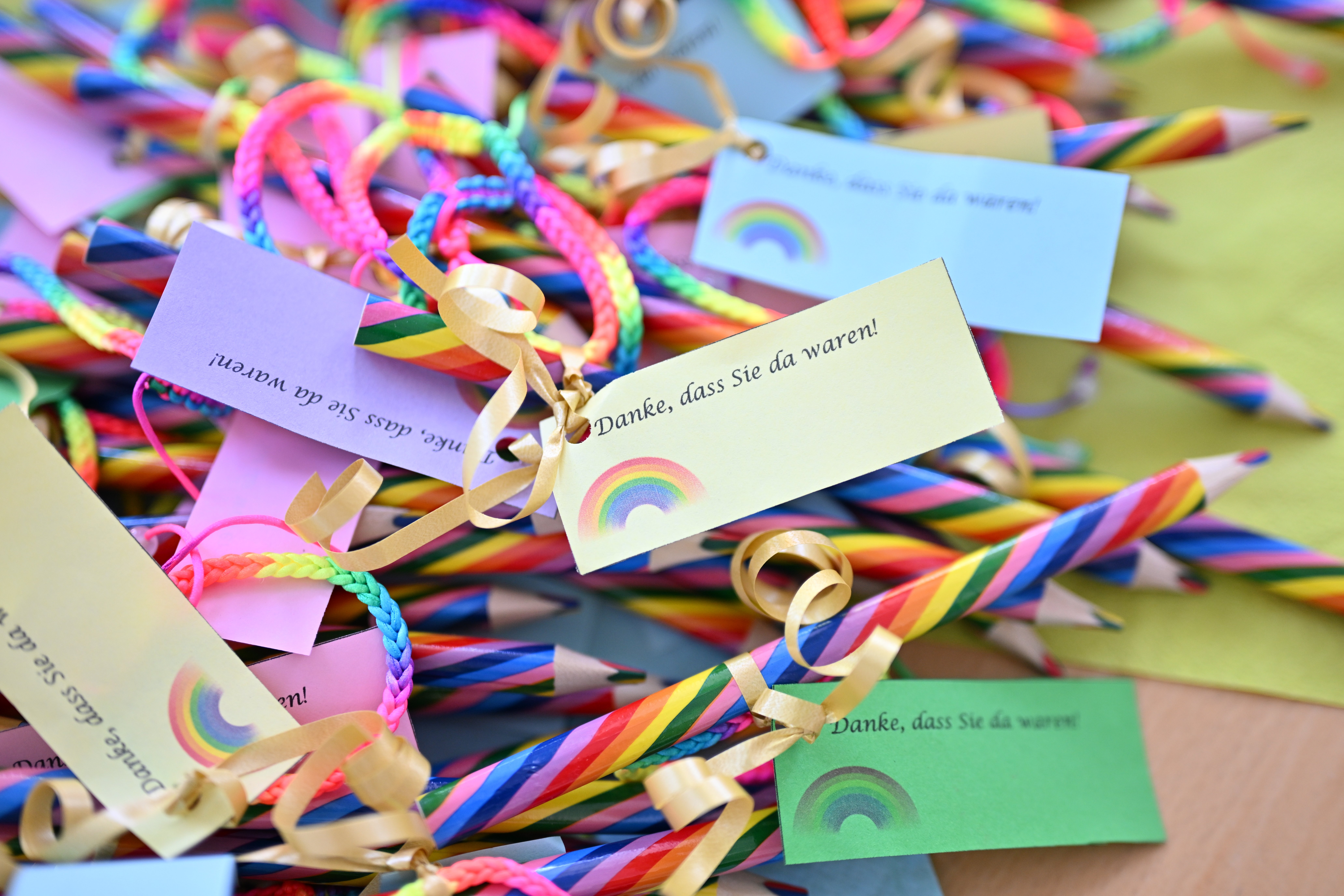 Bunte Stifte mit Etiketten und Regenbogenmotiv.