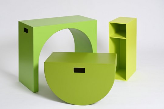 Grüne Möbel in geometrischen Formen: Tisch, halbkreisförmiger Hocker und Regal.