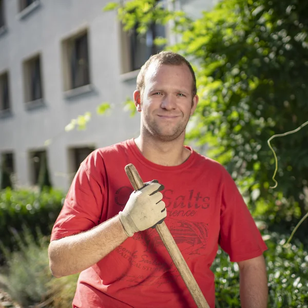 Beschäftigter aus dem Garten- und Landschaftsbau im Garten eines Kunden