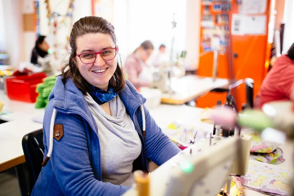 Junge Frau an der Nähmaschine in den Franz Sales Werkstätten.