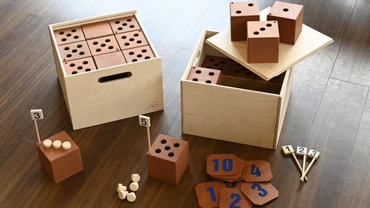 Mathe-Lernspiel mit Kisten, Würfeln, Korken und Ergebis-Plättchen aus Holz