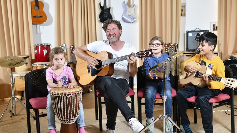 Lehrer und Schulkinder musizieren