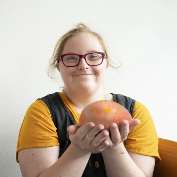 Beschäftigte hält gelbe Kerze in der Hand