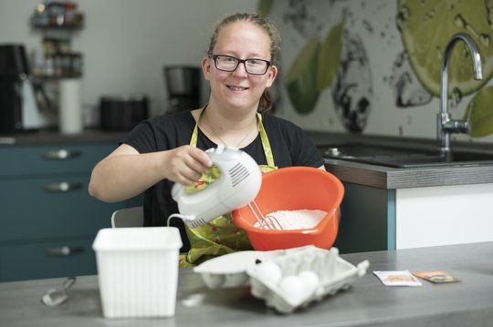 Junge Frau bäckt in ihrer Küche einen Kuchen.