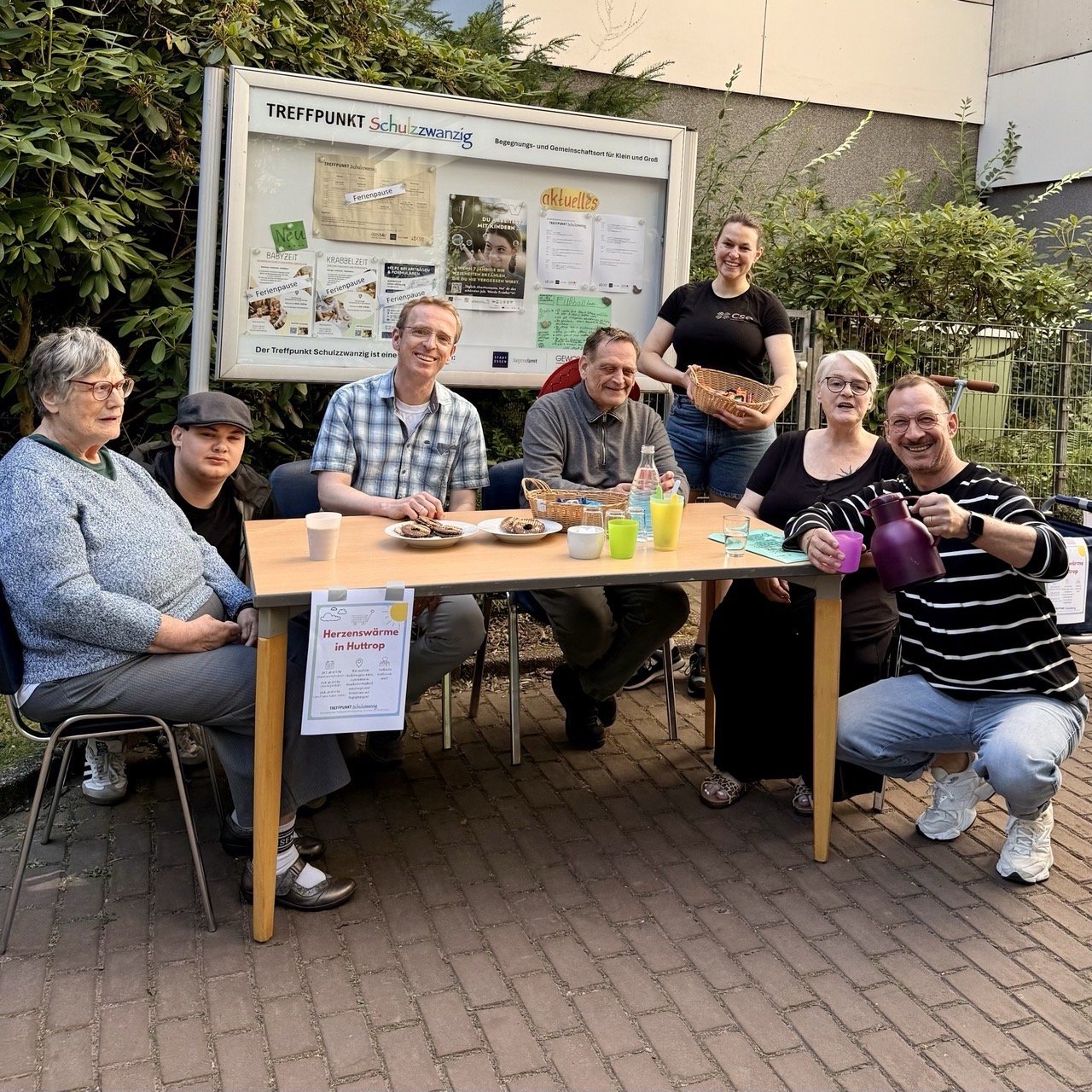 Akteure des Projekts Herzenswärme an einem Stand mit Getränken und Snacks