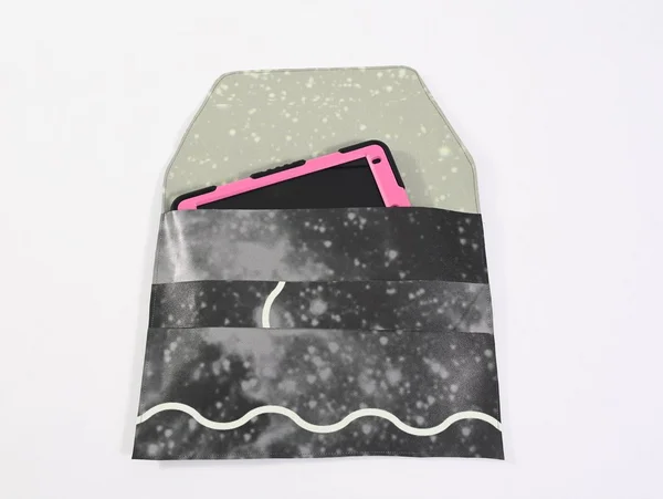 Tablet in pinkem Case in schwarz-grauer Verpackung mit Wellen- und Punktmuster.