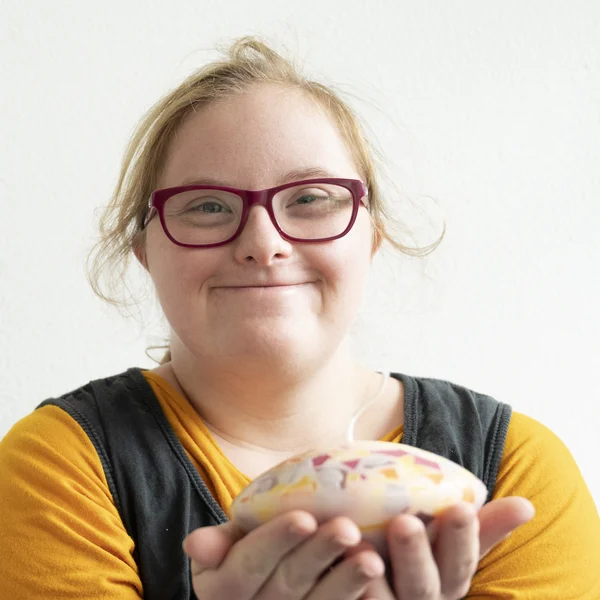 Lächelnde Beschäftigte, die stolz eine Kerze in den Händen hält.