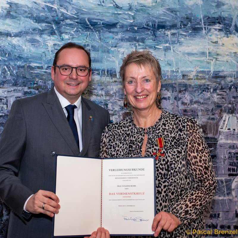 Susanne Buers und OB Thomas Kufen mit Bundesverdienstkreuz und Urkunde