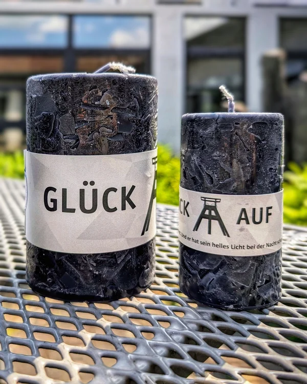 Zwei schwarze Kerzen mit der Aufschrift "Glück Auf"