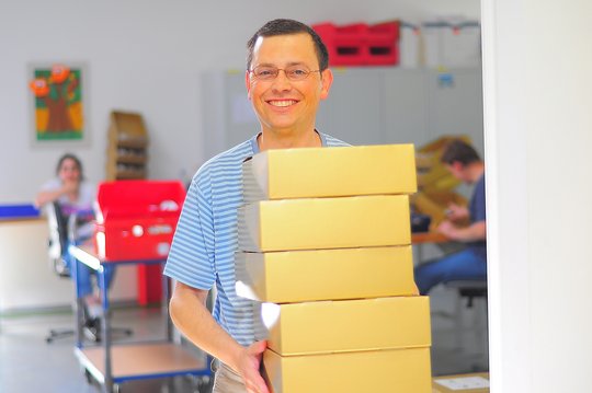 Bechäftigter trägt Kartons