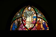 Über dem alten Eingang vom Haupthaus sind alte Glasfenster mit einem Bild von Franz von Sales zu sehen. Am besten kann man das Bild von innen sehen.