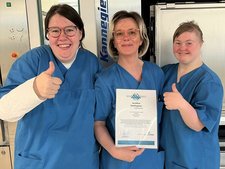 Das Wäscherei-Team ist stolz: Die Urkunde zeigt, dass alle sehr gute Arbeit machen.