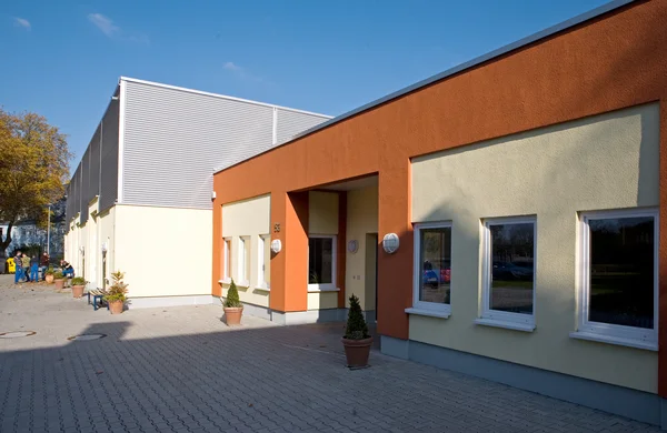 Modernes Gebäude mit farbiger Fassade bei sonnigem Wetter.