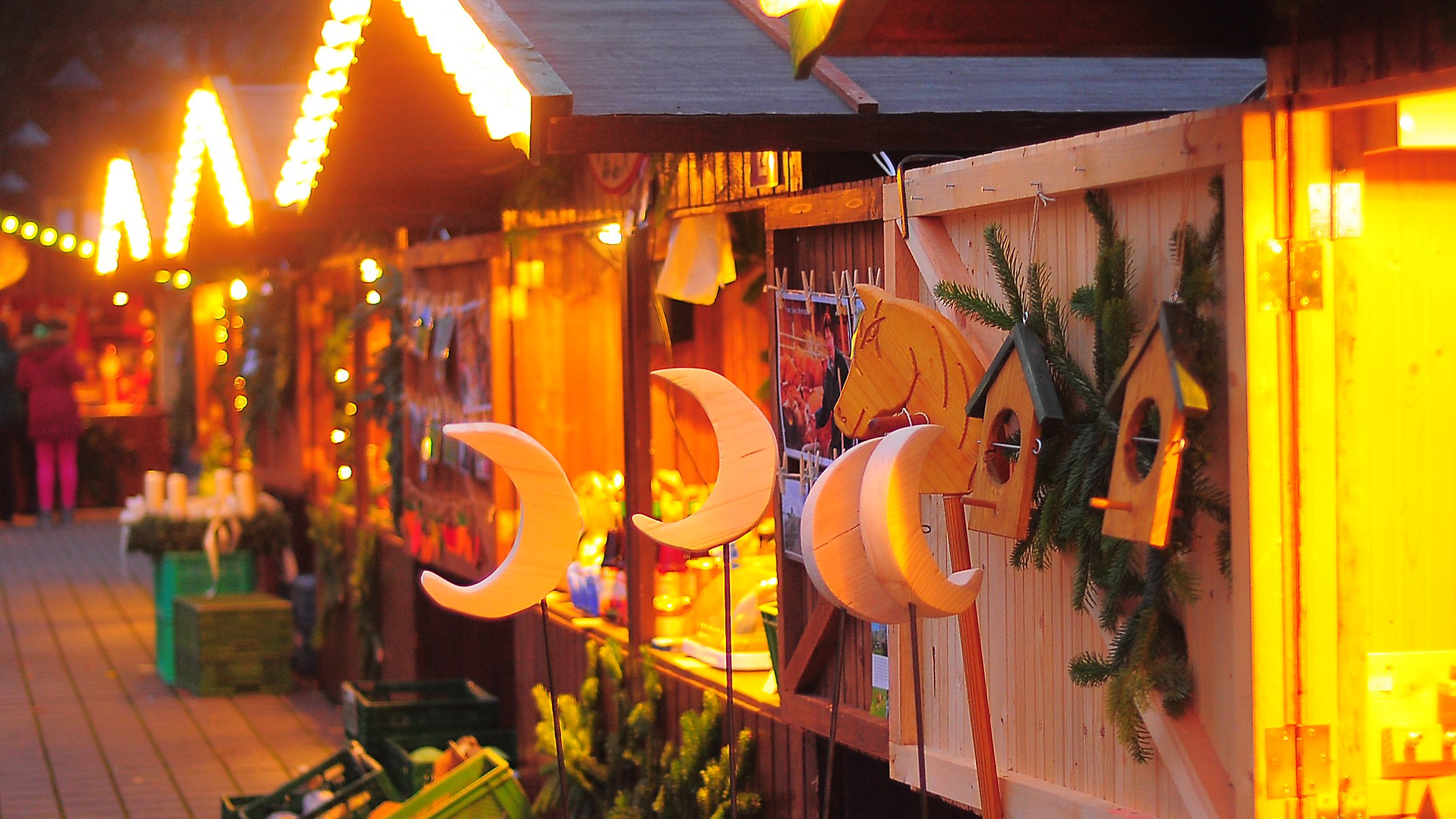 Beleuchtete Stände des Weihnachtsmarkts im Franz Sales Haus mit Produkten aus den Werkstätten.