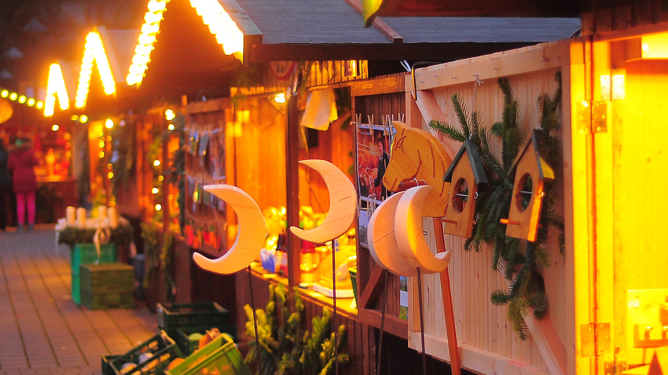 Beleuchtete Stände des Weihnachtsmarkts im Franz Sales Haus mit Produkten aus den Werkstätten.