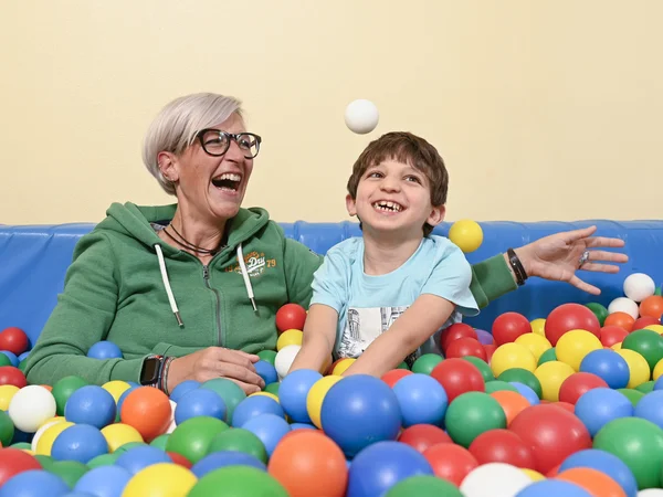 Familienhelferin mit Kind im Bällebad