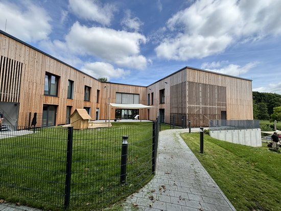 Das Gebäude der Auszeit Bochum: Moderne Architektur mit einer Fassade aus Holz und viel Glas