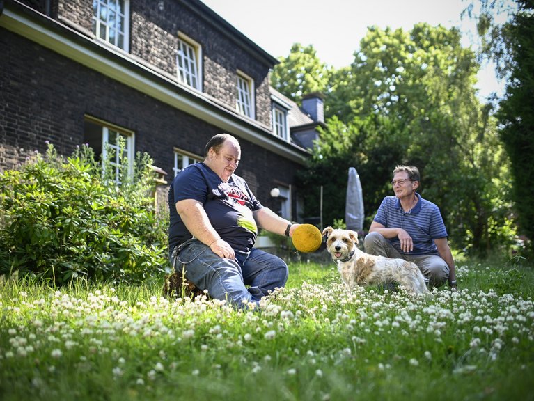 Der im Franz Sales Haus ehrenamtlich tätige Reiner (rechts im Bild) besucht mit seinem Hund Wilma regelmäßig eine Wohngruppe in Frillendorf. Olli ist begeistert davon, dass er mit der kleinen Hundedame spielen und spazieren gehen kann. 