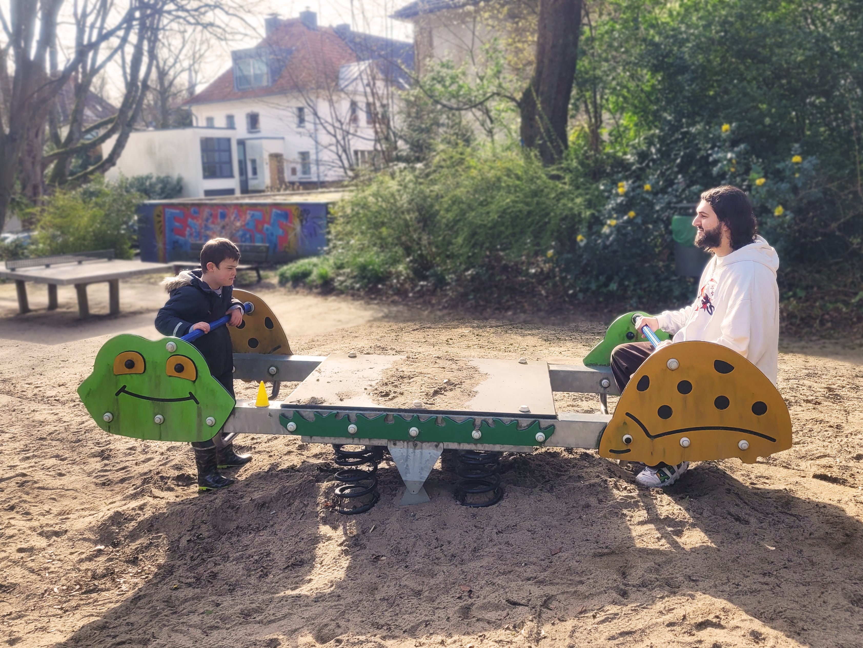 Zwei Personen auf einem Spielgerät auf dem Spielplatz