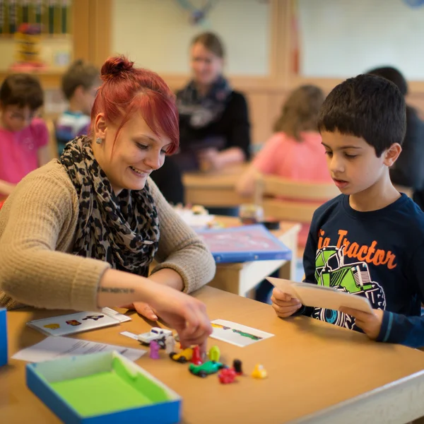 Auszubildende fördert kleinen Jungen durch ein Spiel.