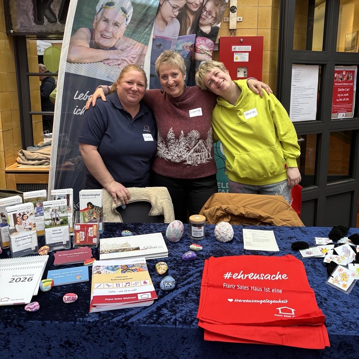 Drei Frauen hinter dem Tisch mit Infomaterialien aus dem Franz Sales Haus
