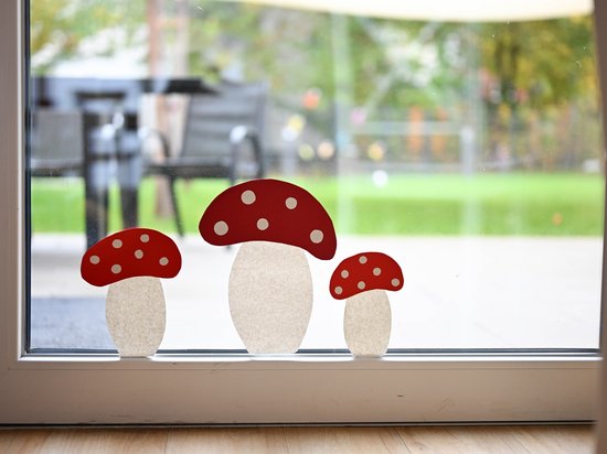 Blick aus einem mit Pilzen herbstlich dekorierten Fenster in den Garten der Auszeit Bochum