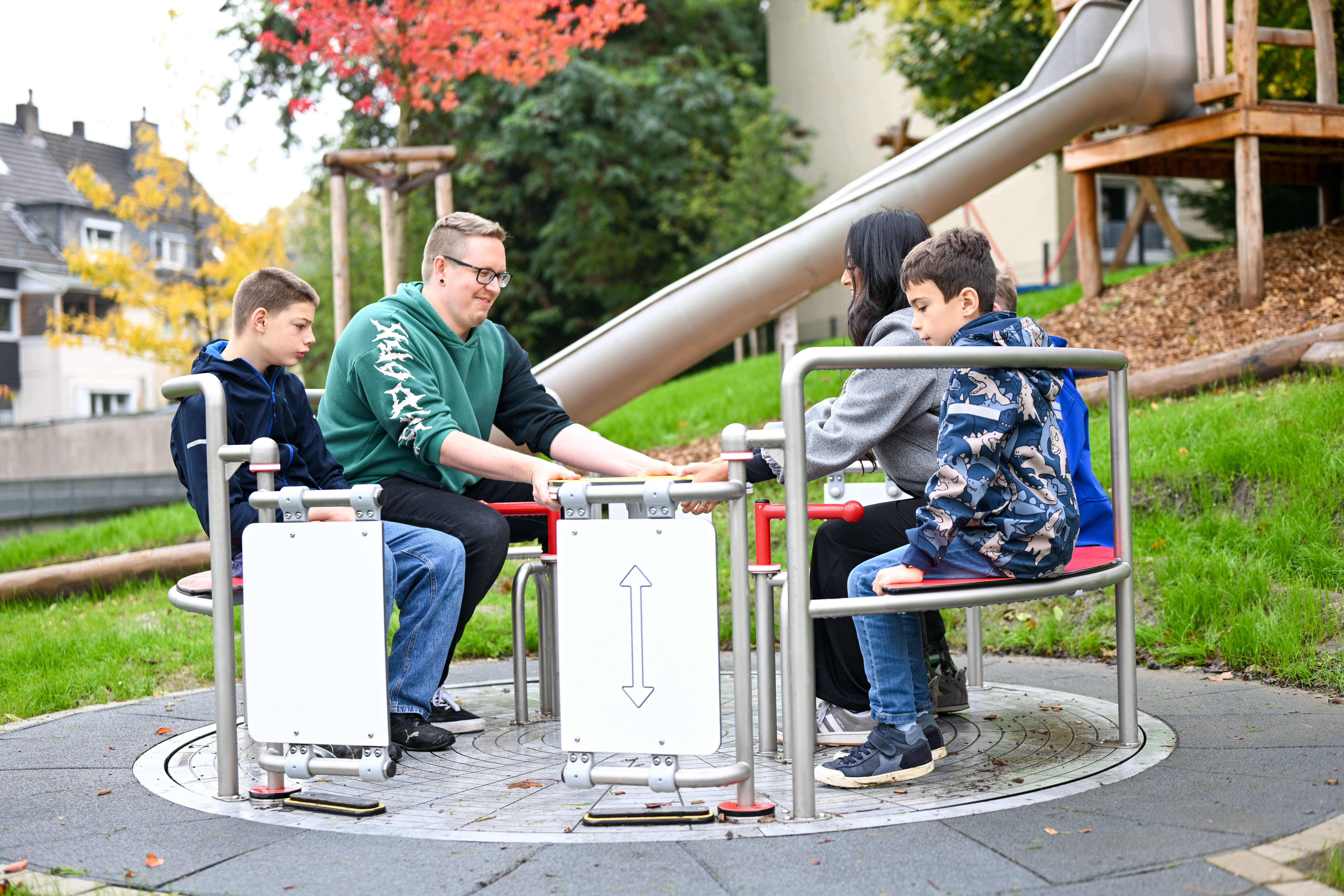 Mehrere Personen sitzen auf einem Spielgerät, das sich dreht