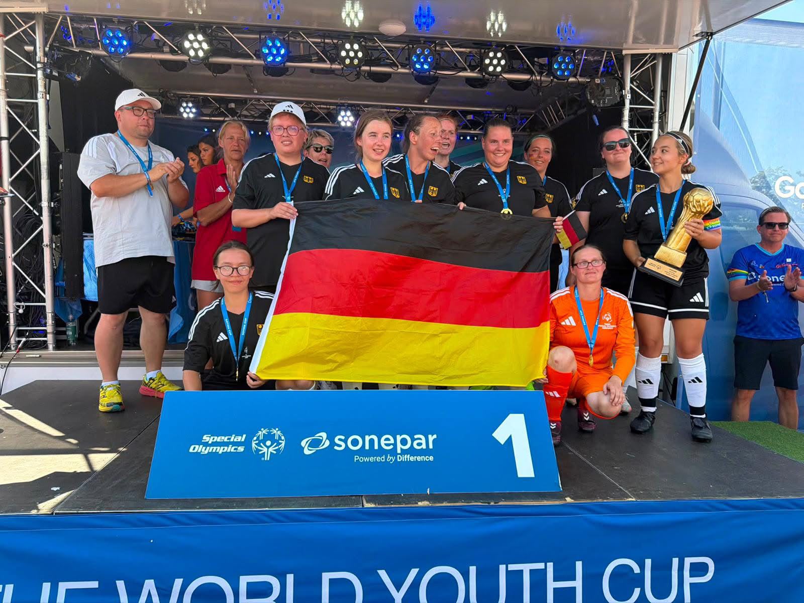 Das Damen-Team mit Medaillen, Pokal und Deutschland-Fahne.