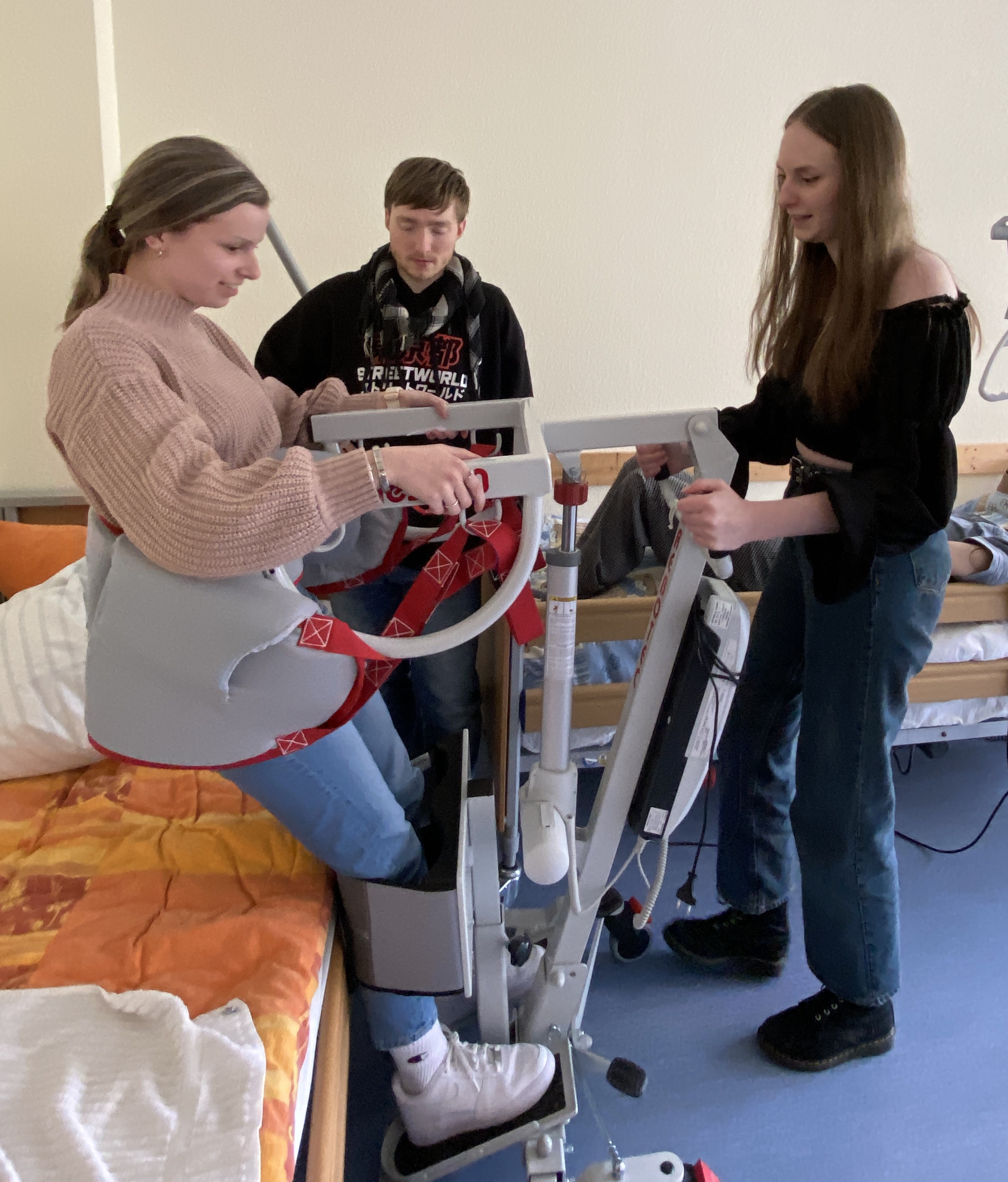 Junge Leute probieren ein Hifsmittel zum Aufstehen aus