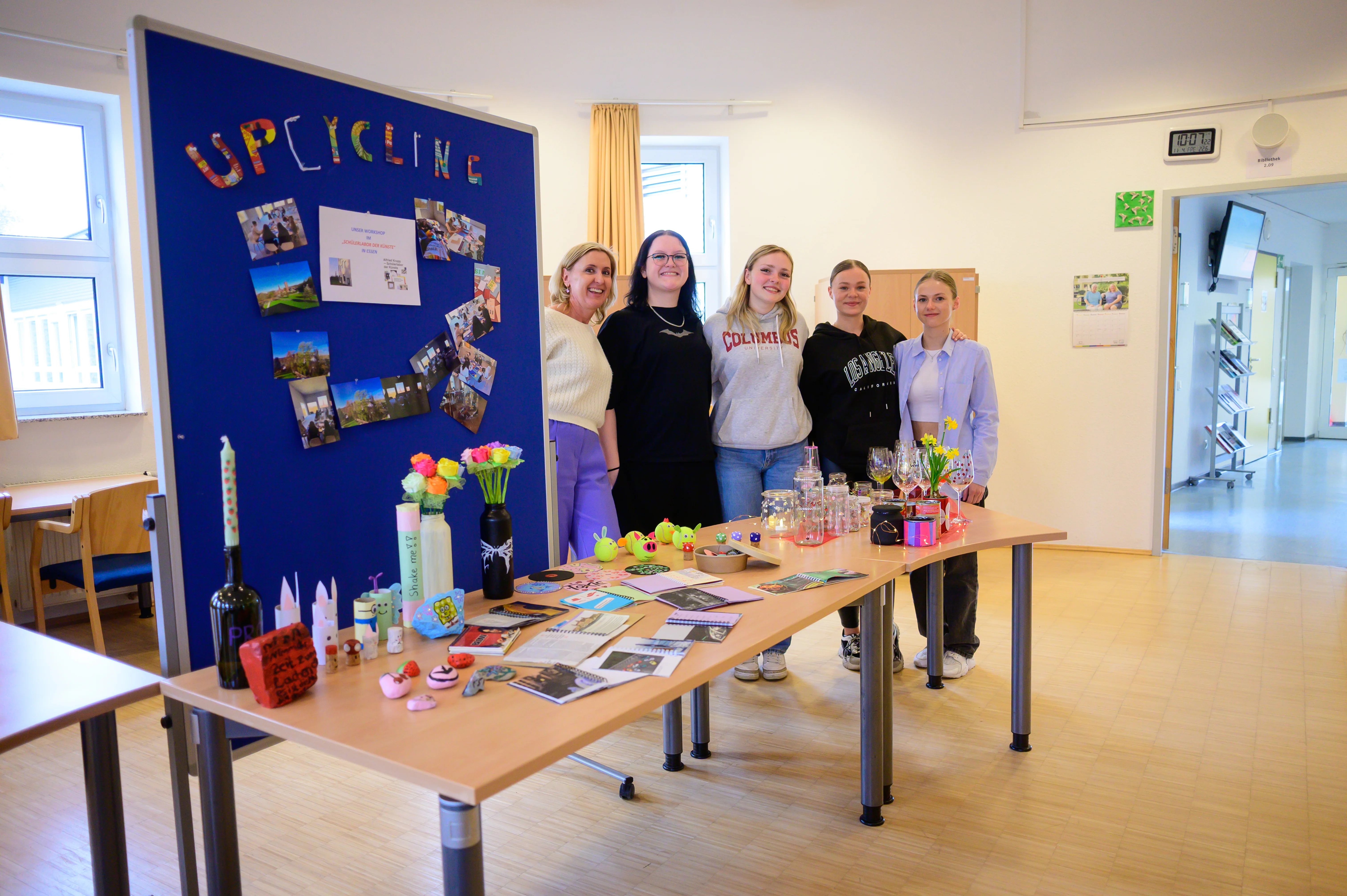 Fünf Personen stehen neben einer Projektarbeit zum Thema Upcycling - symbolisch für Ausbildungsberufe.